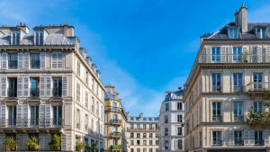 Historische Stadthäuser mit Fensterläden und Balkonen – Symbolbild für urbane Mietverhältnisse und Wohnungseigentum in Altbauten