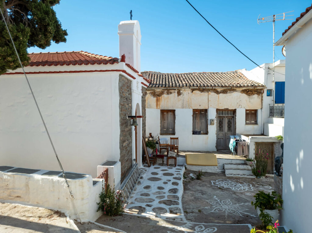 Traditionelles Ziegelhaus neben griechisch-orthodoxer Kapelle auf der Insel Kythnos -Beispiel für historische Bausubstanz in Griechenland